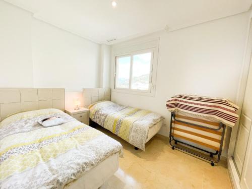 um quarto com 2 camas e uma janela em Oasis Beach III em Altea la Vieja