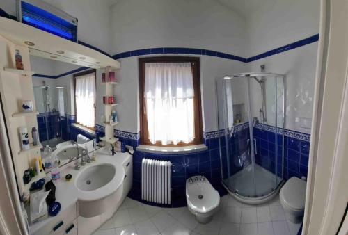a blue and white bathroom with a sink and a toilet at Villa mit Whirlpool und phantastischer Aussicht in Capoliveri