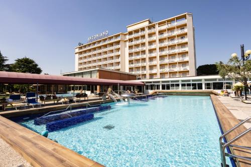 a large swimming pool in front of a hotel at Hotel Terme Antoniano in Montegrotto Terme