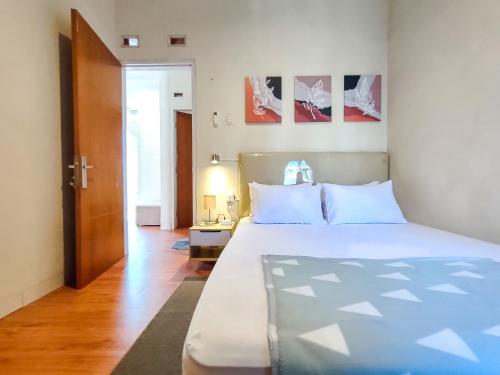 1 dormitorio con 1 cama grande y suelo de madera en SleepHouse 2BR Cozy Place for StayCation en Cirebon