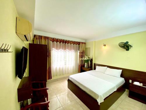 ein Schlafzimmer mit einem weißen Bett und einem Fenster in der Unterkunft Hotel Kien Nga in Thach Loi