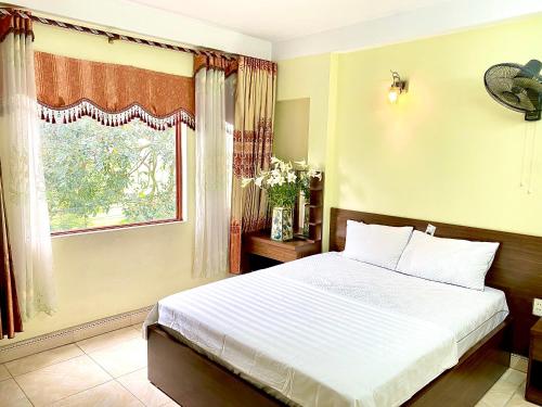 um quarto com uma cama grande e uma janela em Hotel Kien Nga em Thach Loi