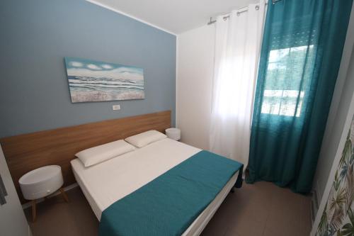 a small bedroom with a bed and a window at Residence Verdena appartamento 02 in Rosolina Mare