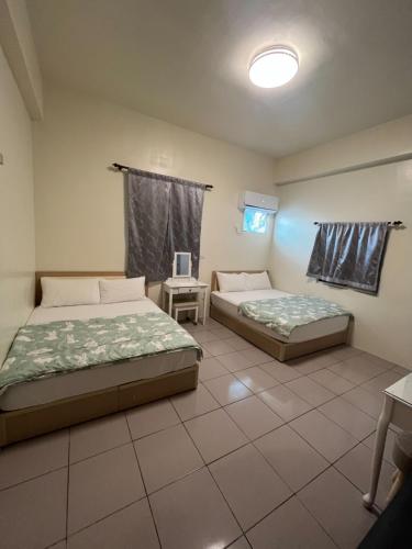 綠島鄉的住宿－新宇別館，一间卧室设有两张床、一张桌子和一个窗口