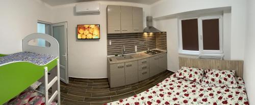 a small room with a bed and a kitchen at Garsoniera la malul marii in Mangalia