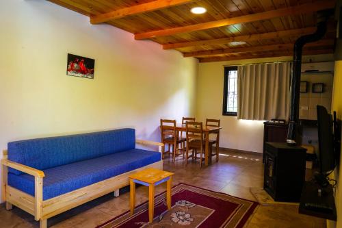 a living room with a blue couch and a table at Graneroverde Resort in Al Qbayyāt