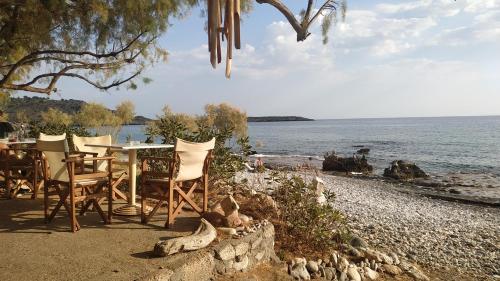 LivanianáにあるGeorgoshouse Lykos beach Sfakiaの水辺にテーブルと椅子