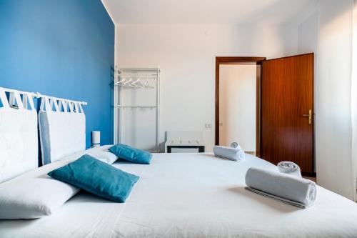 ein großes weißes Bett mit blauen Kissen darauf in der Unterkunft IL MONTE in Erice