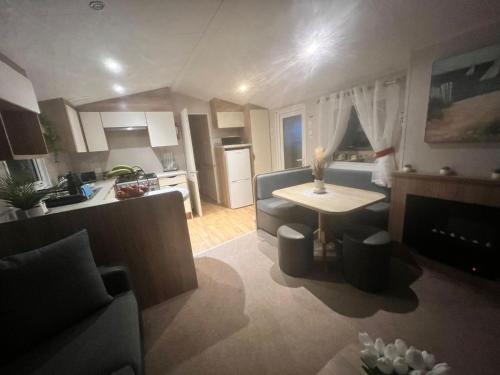 a kitchen and a living room with a couch and a table at "Black Pearl "- 2 Bed, 6 Berth Caravan in Humberston