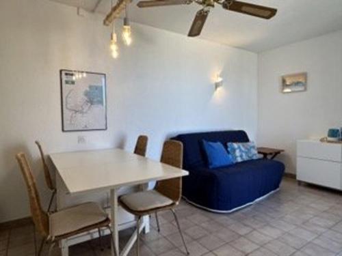 un salon avec une table et un canapé bleu dans l'établissement Appartement 2 pièces avec terrasse et parking à Banyuls-sur-Mer - FR-1-225C-96, à Banyuls-sur-Mer