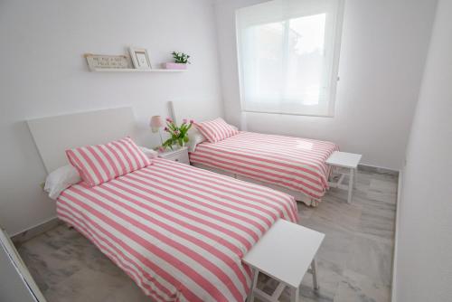 2 bedden met gestreepte lakens in een kleine kamer bij La Dama de Noche - Marbella Puerto Banus in Marbella