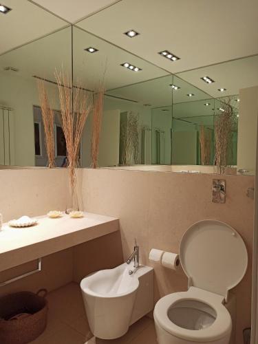 bagno con servizi igienici, lavandino e specchio di Attico San Domenico a Trapani