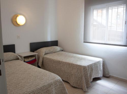una stanza con due letti e una finestra di Ca la Estrella I l'Estartit a L'Estartit