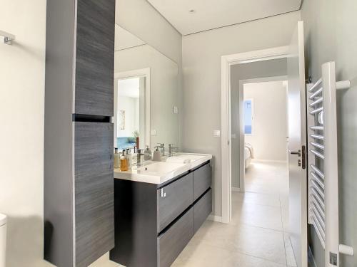 uma casa de banho com um lavatório e um espelho em Avocado Villa by LovelyStay em Funchal