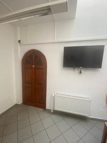 um quarto com uma porta e uma televisão na parede em Klamovka Hostel em Praga