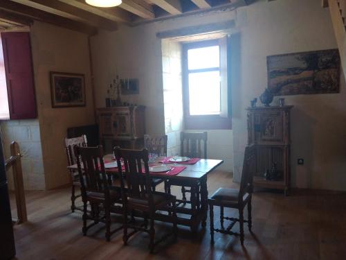 uma sala de jantar com uma mesa e cadeiras e uma janela em Gîte Brilhac em Monts-sur-Guesnes