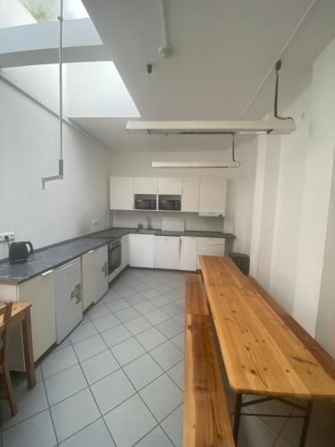 uma grande cozinha branca com uma mesa de madeira em Klamovka Hostel em Praga