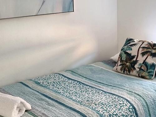 a bedroom with a bed with a palm tree pillow at CHILL-OUT LAKESIDE - Wallis Lake Forster in Forster