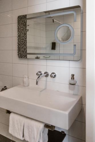 a bathroom with a white sink and a mirror at Hotel Amerika in Hoek van Holland