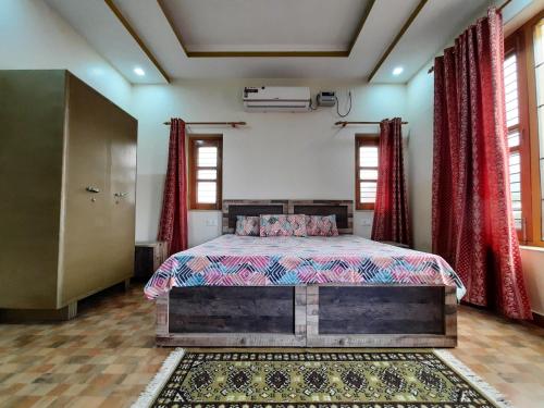 a bedroom with a bed and red curtains at Bora's Homestay in Haldwāni