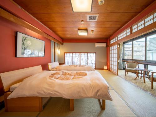 two beds in a room with red walls at Yanagiso in Toyooka