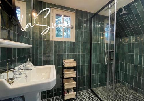 een groene betegelde badkamer met een wastafel en een douche bij Villa Brigitte in Le Touquet-Paris-Plage