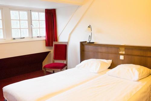 een hotelkamer met 2 bedden en een raam bij Hotel Konbanwa in Heilig Landstichting