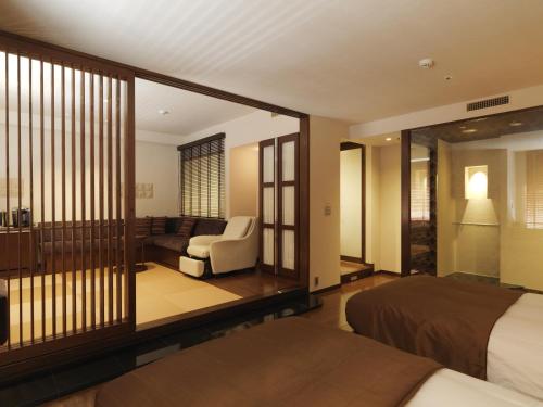 Habitación de hotel con cama y sala de estar. en Jozankei Tsuruga Resort Spa Mori no Uta, en Jozankei