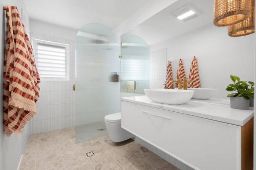 Vibes At Five Noosa في نوسافيل: حمام أبيض مع حوض ومرحاض