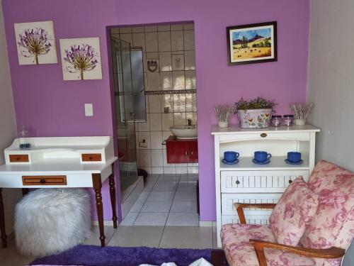 een badkamer met paarse muren, een wastafel en een stoel bij Victorian Villa Westdene Benoni in Benoni