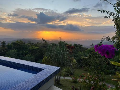 a view of the sunset from a house with a swimming pool at Villa La Vista of Panama City and magestical mountains from infinity pool in Cerro Azul