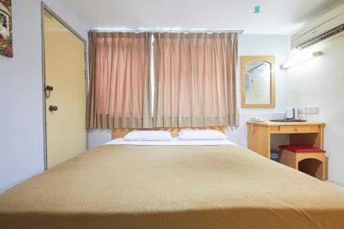 ein Schlafzimmer mit einem großen Bett und einem Fenster in der Unterkunft Tang City Hotel at Petaling Street in Kuala Lumpur