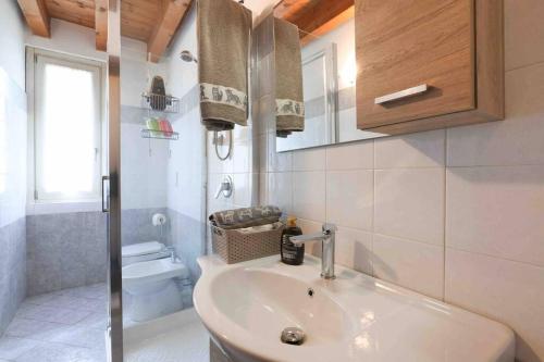 a bathroom with a sink and a toilet and a mirror at Centro storico Bilocale Check in 24h Wi-Fi Bus 500m in Borgo di Terzo