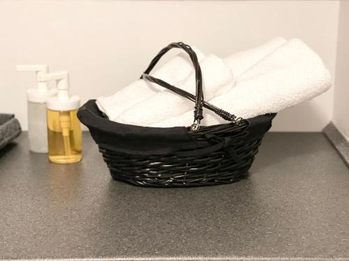 a basket of towels on a counter with a bottle of soap at Scandinavian Apartment Hotel - Lunden 1 - Central 3 bedroom apartment on two floors in Horsens
