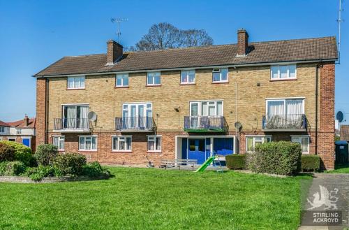 a large brick building with a lawn in front of it at Lux Homes in Sunbury Common