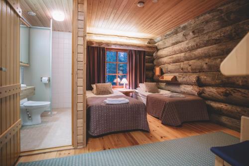 a room with two beds and a bathroom at Santa's Hotel Aurora & Igloos in Luosto