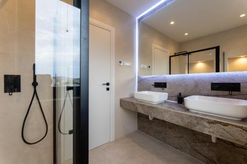 łazienka z 2 umywalkami i prysznicem w obiekcie Villa Duje w mieście Kaštel Stari