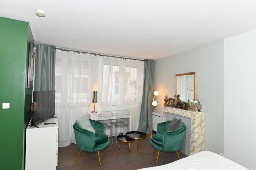 リヨンにあるAppart' Brestのベッドルーム1室(デスク、緑の椅子2脚付)