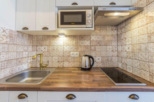 a kitchen with a sink and a microwave at Scandinavian Apartments in Kyiv