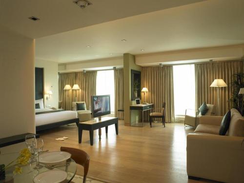 um grande quarto de hotel com um quarto e uma sala de estar em Mirage Hotel em Mumbai