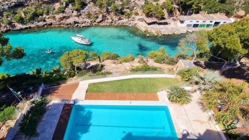 uma vista aérea de uma piscina ao lado de uma massa de água em * THE CRYSTAL BAY * Luxury bay and see view Villa em Cala Pi