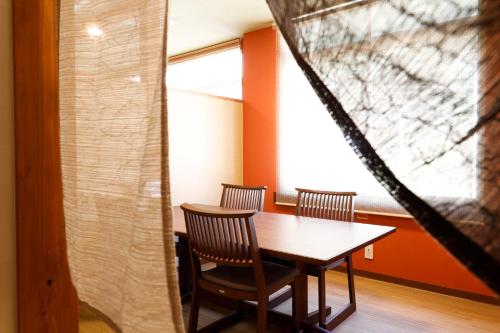 a table and chairs in a room with a window at Yanagiso in Toyooka