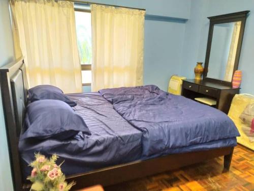 a bedroom with a purple bed and a desk at Lagenda Condominium Melaka in Melaka