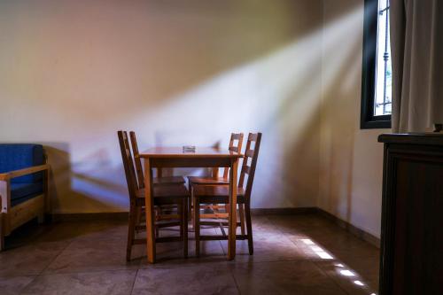 a table and chairs in a room with a window at Graneroverde Resort in Al Qbayyāt