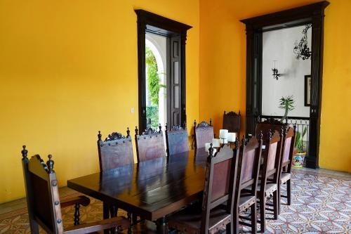 a dining room with a wooden table and chairs at VILLA MERIDA BOUTIQUE HOTEL - Adults Only in Mérida