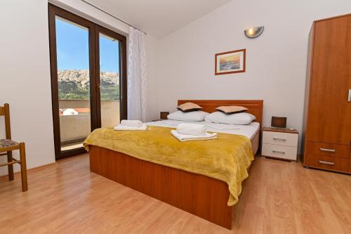 sypialnia z łóżkiem i dużym oknem w obiekcie Apartments Andrea I w Bašce