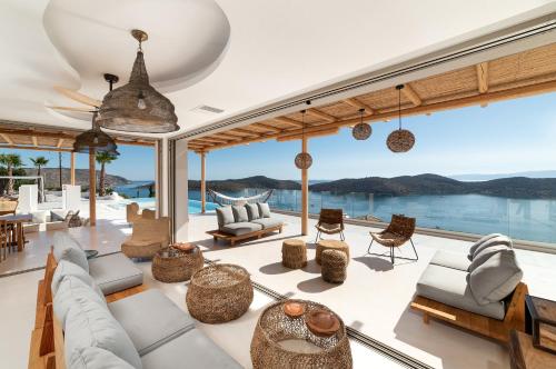 a living room with a view of the ocean at New Serenity Art Villa Elounda in Elounda