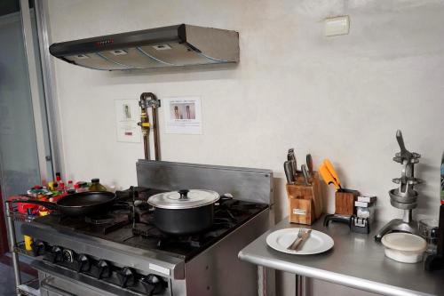 a kitchen with a stove with two pots and pans at VILLA MERIDA BOUTIQUE HOTEL - Adults Only in Mérida