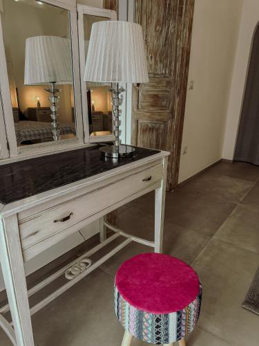 a dressing table with a mirror and a pink stool at Soffio del Salento in Matino