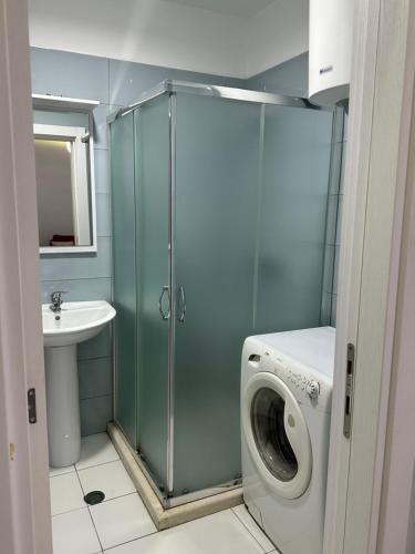 a bathroom with a shower and a washing machine at Dream Apartments Shengjin in Shëngjin